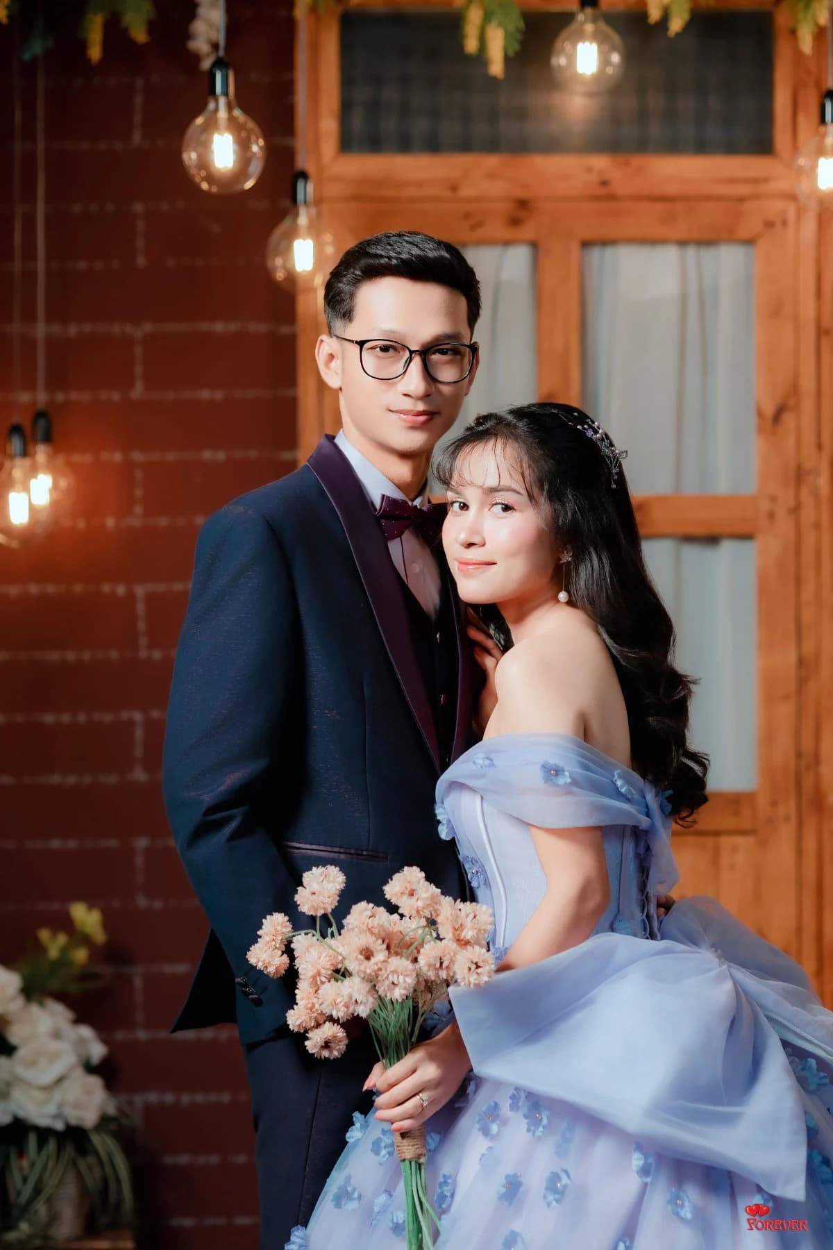 Aung in a navy suit and Hnin in a pastel blue gown